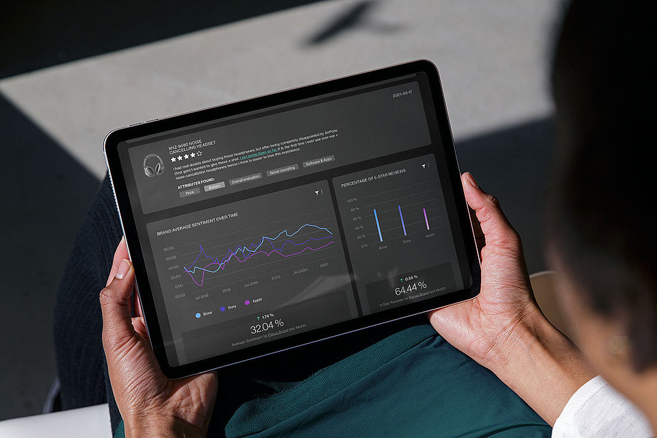 A woman holds a tablet with a dashboard of XPLN's JUDGMENT DAY software solution