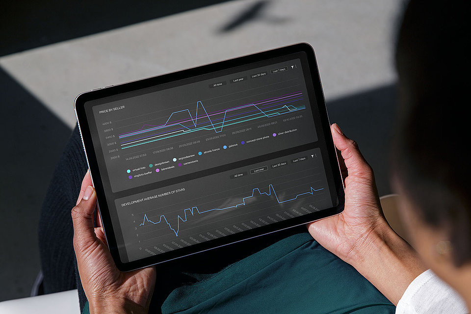 A woman holds a tablet with a dashboard of XPLN's DELOREAN software solution